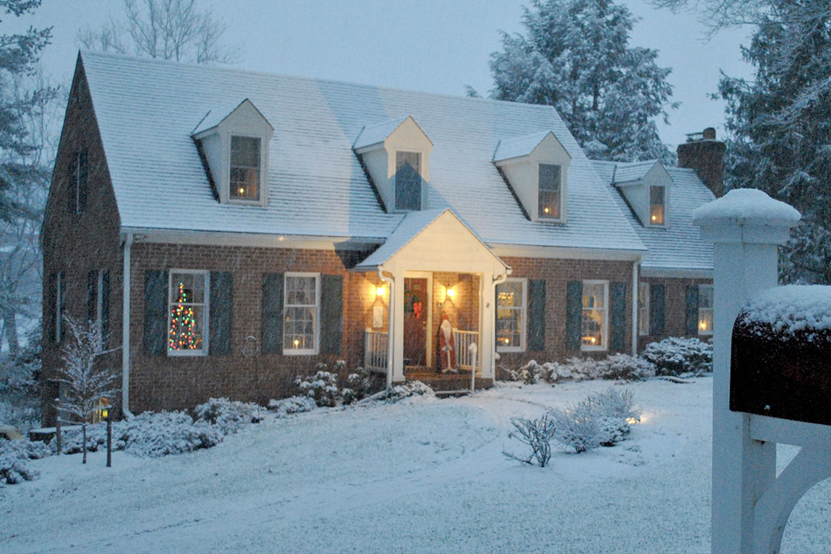 A softly lit home covered in a light dusting of snow.